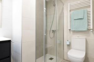 a white bathroom with a shower and a toilet at Apartamentos Nature in Cangas del Narcea