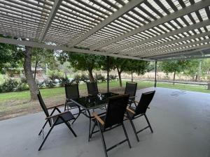 een patio met een tafel en stoelen onder een pergola bij La Casona in Abasto