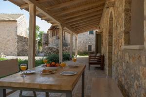 una mesa de madera con un bol de fruta en el patio en AVLI - Tranquil stonehouse in Lefkada, en Alexandros