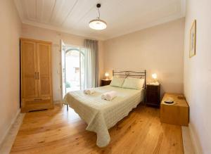 Schlafzimmer mit einem Bett und Holzboden in der Unterkunft AVLI - Tranquil stonehouse in Lefkada in Alexandros