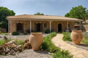two large vases in front of a stone house at AVLI - Tranquil stonehouse in Lefkada in Alexandros