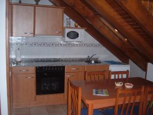 a kitchen with a table and a sink and a stove at Ca del Pòsol in Durro