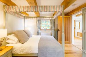 a bedroom with a bed with a canopy at Gamekeeper's Lodge- a cottage with a spectacular view in Port of Menteith