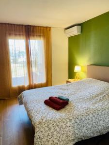 a bedroom with a bed with two red towels on it at Le Marine 4 in Cogolin