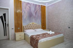 a bedroom with a bed with a painting on the wall at Luxury Milan Gabala hot pool, mountain view, cable car in Gabala