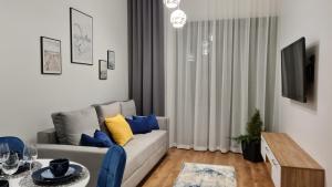 a living room with a couch and a tv at DAIRA APARTMENTs in Ustronie Morskie