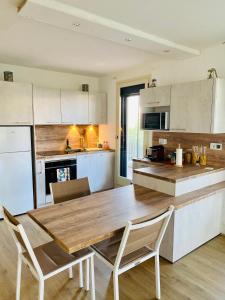 uma cozinha com uma mesa de madeira e cadeiras em Le Marine 4 em Cogolin