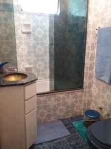 uma casa de banho com um chuveiro, um lavatório e um WC. em Aconchego da te no Rio de Janeiro