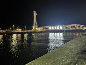 een brug over een waterlichaam 's nachts bij Luxoro Park Apartament Nero in Ustka