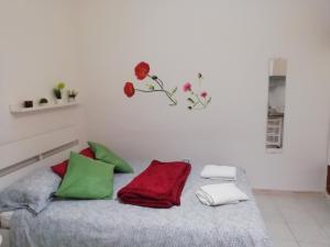 - une chambre dotée d'un lit avec des oreillers verts et rouges dans l'établissement otto di denari, à Naples