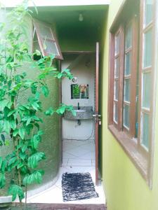 an open door to a bathroom with a plant at Karaguashouse in Florianópolis