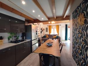 a kitchen and living room with a wooden table in a room at Les Gentianes, Appartement au pied des pistes in Saint-Pierre-dels-Forcats