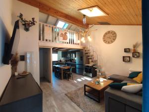 a living room with a couch and a clock on the wall at Les Gentianes, Appartement au pied des pistes in Saint-Pierre-dels-Forcats