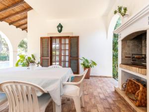 a dining room with a white table and chairs and a fireplace at Akisol Faro Relax in Faro