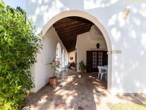 una entrada arqueada a un edificio blanco con techo de madera en Akisol Faro Relax, en Faro