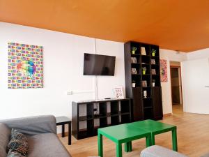 un soggiorno con divano e tavolo verde di Arc House Barcelona a Barcellona