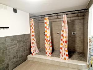 バルセロナにあるArc House Barcelonaのバスルーム(オレンジと白のカーテン付きのシャワー付)