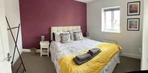 um quarto com uma cama grande e paredes roxas em Stunning Large Detached Gloucester, 4 beds, 3 bedroom, 2 bathroom property, Nr Chelt, The Docks and Quays sleeps 6 em Gloucester