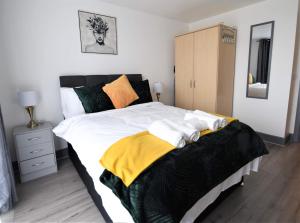 una camera da letto con un grande letto con una coperta gialla e nera di Stunning, 1-Bedroom Cosy Apartment in the Centre of Birmingham a Birmingham