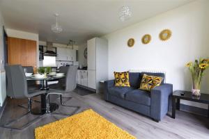 un soggiorno con divano blu e tavolo di Stunning, 1-Bedroom Cosy Apartment in the Centre of Birmingham a Birmingham