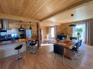 a kitchen and dining room with a table and chairs at Chalet Miel de la Cayolle-Estenc in Entraunes