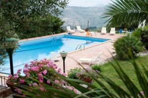 a swimming pool with chairs and flowers in a yard at Villa Ivoni 1 in Campofelice di Roccella