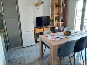 a kitchen with a table with chairs and a refrigerator at Ema in Brela