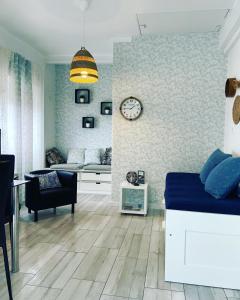 a living room with a bed and a clock on the wall at Soul Surfer in Peniche