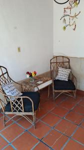 una habitación con 2 sillas y una mesa con flores. en La Toscana en Salta