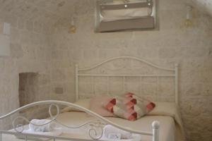 Una cama blanca con una almohada roja encima. en B&B Fiano Marchione, en Castellana Grotte
