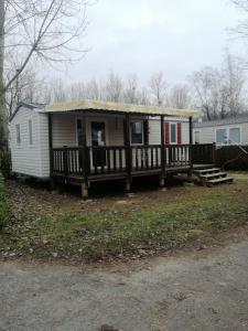 a mobile home with a porch and a deck at SAS MHVACANCES LOUE MOBILHOME 2 CHAMBRES PROCHE CHATEAUX et ZOO BEAUVAL in Onzain