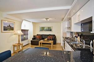 a kitchen and living room with a couch and a table at Croft Mill in Hebden Bridge
