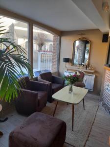 uma sala de estar com sofás e uma mesa de centro em Hotel bar Saint Christophe em Le Tilleul