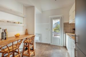 cocina con encimera con sillas y nevera en Stylish Mini-House with Garden & Beach, en Bijela