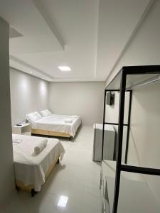 CastanhalにあるHotel Castanhalのベッド2台と窓が備わる客室です。