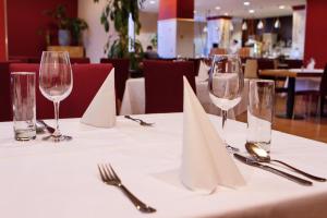 ein Tisch mit weißen Servietten und Weingläsern darauf in der Unterkunft Hotel Expo in Bratislava