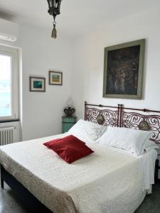 a bedroom with a bed with a red pillow on it at Il Conventino delle Cinque Terre - Sea View - AC&WiFi - Vernazzarentals in Vernazza