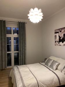 a bedroom with a bed and a chandelier at Apartament Second Home in Strzelce Opolskie