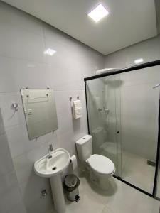 a bathroom with a toilet and a sink and a shower at Hotel Castanhal in Castanhal