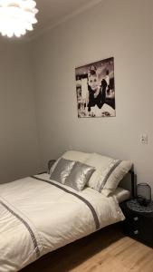 łóżko w sypialni z obrazem na ścianie w obiekcie Apartament Second Home w mieście Strzelce Opolskie