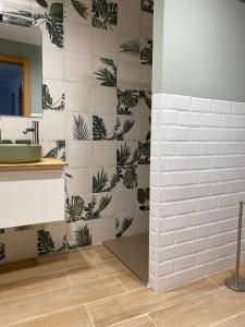 een badkamer met een witte betegelde muur met groene planten bij Apartamento Rural El Retablo in Cetina