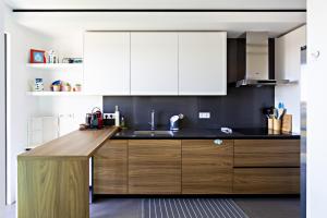 a kitchen with white cabinets and a wooden counter top at My Ocean View in Cabanas de Tavira