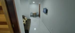 a hallway with a room with a tv and a television Bar H Hbestosbestos at apartamento para até 5 pessoas in Vila Velha