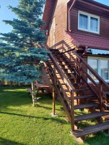 a wooden stairs leading up to a house with a tree at OW HOLIDAY Wicie in Wicie