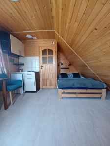 sypialnia z łóżkiem i drewnianym sufitem w obiekcie OW HOLIDAY Wicie w Wiciu