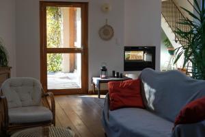 un soggiorno con divano, sedia e TV di La Source a Saint-Saturnin-lès-Apt