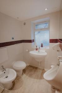 a bathroom with two sinks and a toilet and a window at Cannock Chase Guest House Self Catering incl all home amenities & private entrance in Cannock
