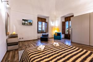 een grote kamer met een bed en een stoel bij La Dimora del Duca Luxury in Giungano