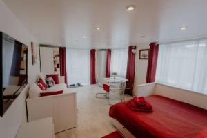 a bedroom with a red bed and a living room at Cannock Chase Guest House Self Catering incl all home amenities & private entrance in Cannock