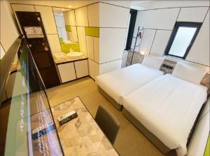 大阪市にある変なホテル大阪 心斎橋のベッドとテーブルが備わる小さな客室です。